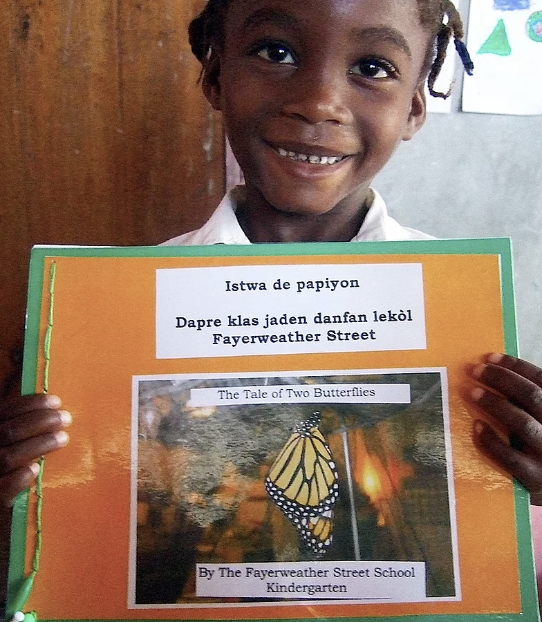 Student holding up their book from the Mother Tongue Books program