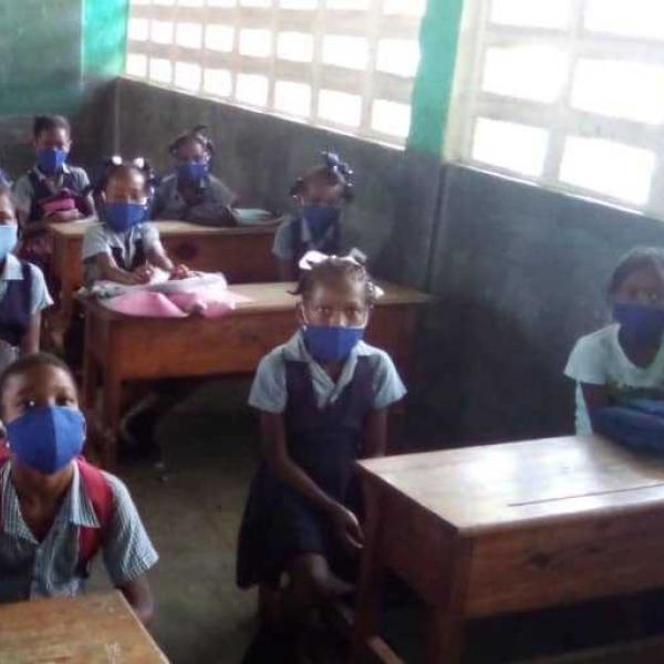 Haitian students physically distanced and wearing masks at school desks