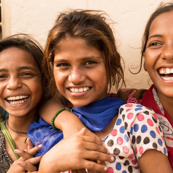 Image of Indian teenage girls smiling with their arms around one another