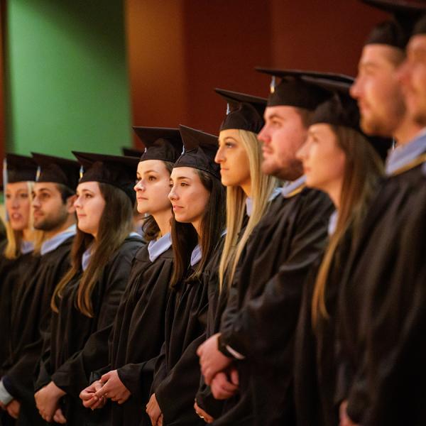 ACE graduates stand to listen to invocation.