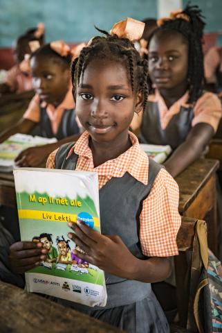Haitian student holding book in classroom