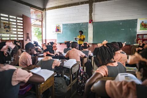 Children in classroom with teacher in Haiti.