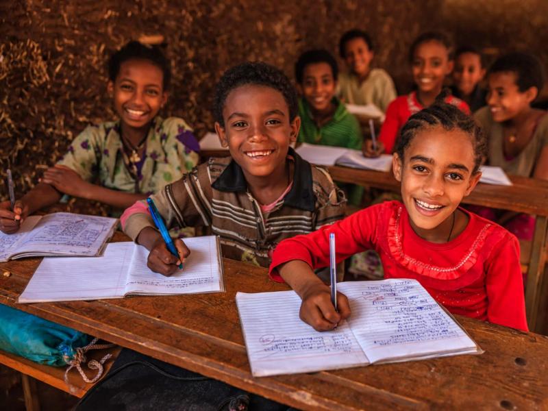 Children at desks for USAID SHARE